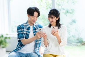 スマホで情報収集をしている若い男女