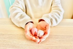 歯の模型を手のひらにのせている。抜歯を連想させる。